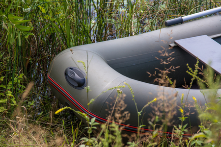 Bow part of inflatable rubber boat in the bush. Rubber boat on the lake shore.の写真素材