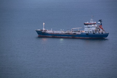 Nautical tanker anchored in sea bay. Early morning.の写真素材