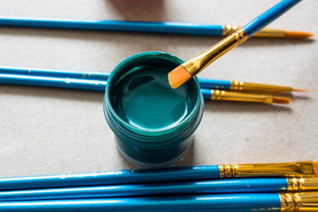 Green plastic jar with paint and brush. Artist's work placeの写真素材