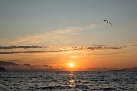 Orange sunset and dark water. Orange dawn on the sea coast.の写真素材