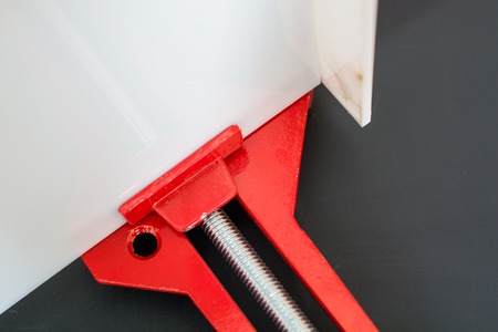 Part of Red clamp on black background. Clamp holding the slat.の写真素材