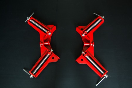 Two red clamp on black background. Corner clamp with two screws.の写真素材