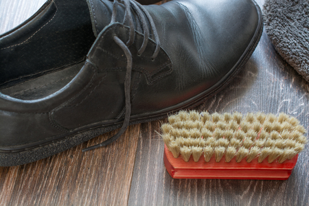 Accessories for shoes cleaning. Man's shoes on wooden surface.の写真素材