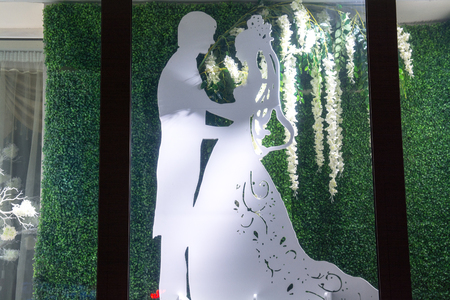Model of the the couple in illuminated showcase. Night window of shop.の写真素材