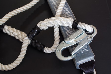 White nylon rope and carabine. Alpine equipment on black surface.の写真素材
