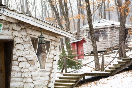 Wooden cabin in snow forest near the stair. Wonderful winter scenery with snow and chalet made from white timber.の写真素材