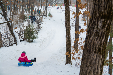 People ride on the snow tubing. Ice slope in the entertainment park.の写真素材