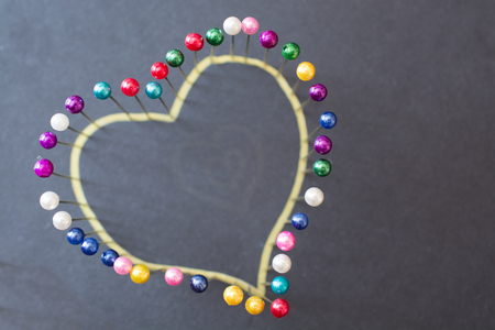 Heart shape from colored pins. Minimalistic image.の写真素材