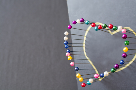 Heart shape from colored pins. Minimalistic image.の写真素材
