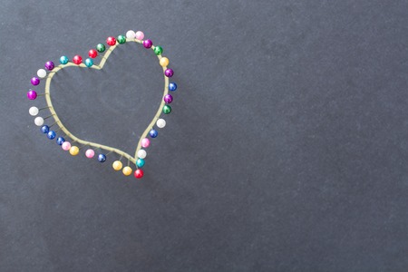 Heart shape from colored pins. Minimalistic image.の写真素材