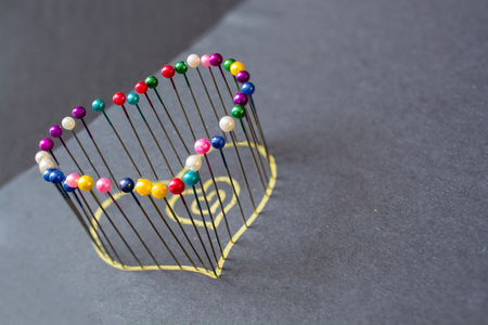 Heart shape from colored pins. Minimalistic image.の写真素材