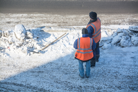 Two road worker near snow heap. Respite of road workers.の写真素材