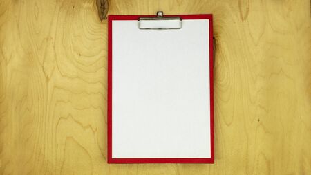 folder tablet with a clip for paper on the background of wooden plywoodの写真素材