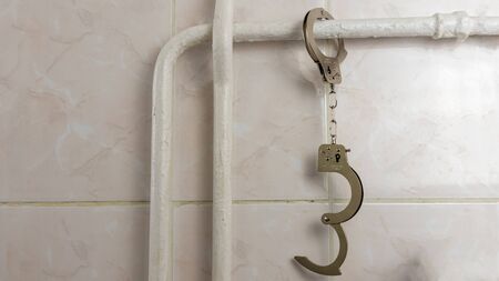 iron handcuffs hang from the heating pipe in the room