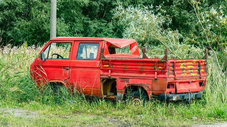 vintage red car after a crash in the grassの写真素材