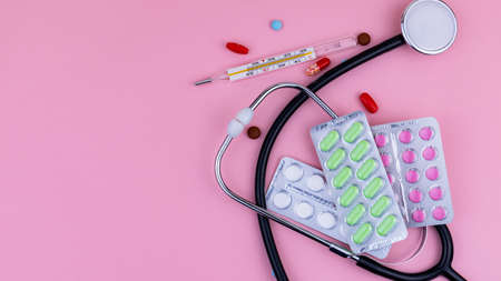 medical instruments and medications on a pink background