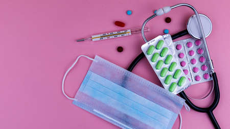 medical instruments and medications on a pink background