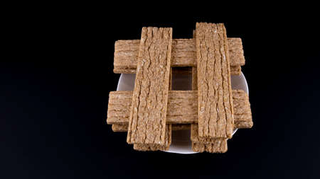 rye fitness crispbread on white saucer on black background, isolatedの写真素材