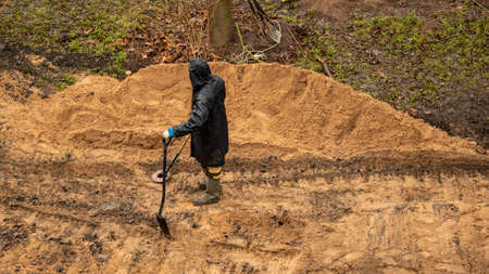 a worker with a metal detector looking for valuable artifacts