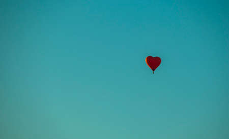 hot air balloon in the form of a red heart on a background of blue sky, backgroundsの写真素材