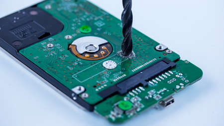 the hard drive from the computer is drilled with a large drill, macro photo