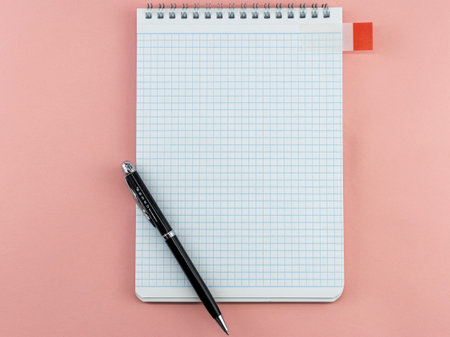 blank sheet of notepad with ballpoint pen on pink background, mock up