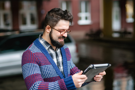 urban stylish bearded man with digital tablet on the street of the city, lifestyleの写真素材