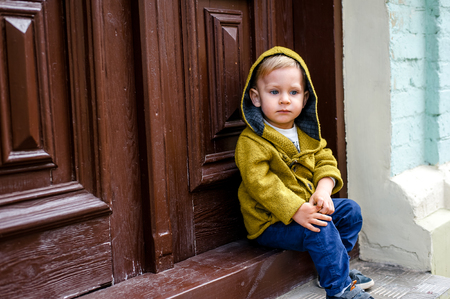 beautiful boy on a walk in the city with his parents in fashionable clothesの写真素材