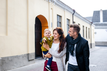 parents with son walking in the city. holding her son in her arms. they are happy. rejoice.の写真素材