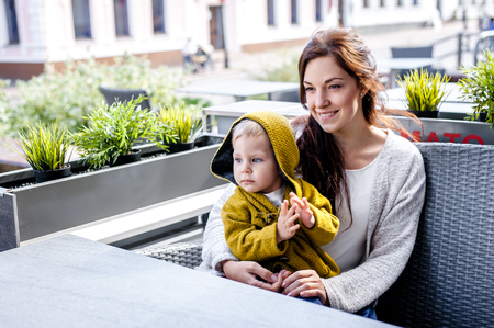 arents with son walking in the city. mother holding her son in her arms. they are happy. rejoice.の写真素材