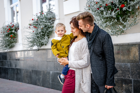 parents with son walking in the city. holding her son in her arms. they are happy. rejoice.の写真素材