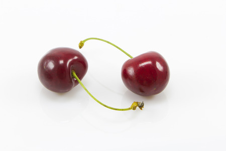 Two red cherry isolated on white backgroundの写真素材