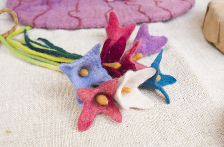 Bouquet of colorful flowers handmade wool, placed on a canvasの写真素材