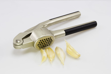 Garlic press and garlic isolated on whiteの写真素材
