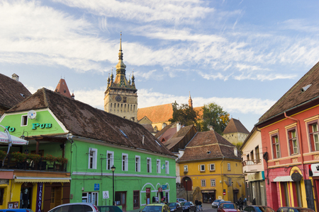 Clock tower sided by old building inside medieval town of Sighisoara, Transylvania, Romaniaのeditorial素材