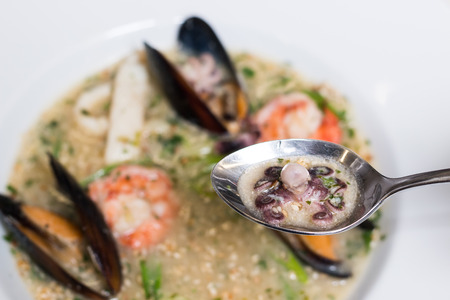 Octopus soup with mussels in a white plateの写真素材