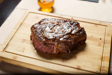 Cut beef steak on wooden cutboard shot with artificial lightの写真素材