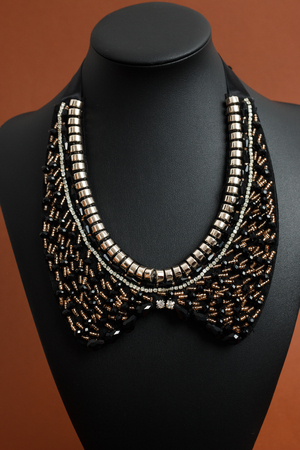Woman's necklace on black leather mannequin shot with artificial lightingの写真素材