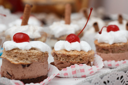 Dessert with chocolate mousse and whipped cream with cherry on top shot in artificial lightの写真素材