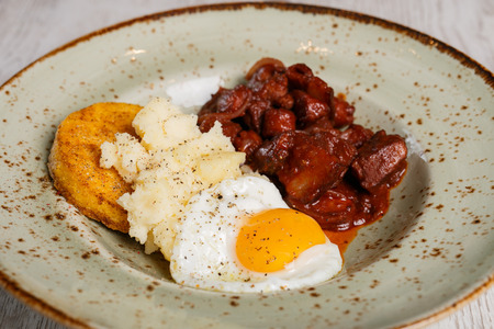 Romanian traditional food, polenta with fried egg and spicy meat and bell cheeseの写真素材