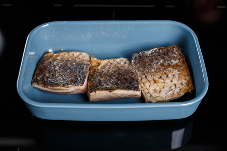 Fried fish fillet in a blue bowlの写真素材