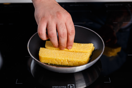 Chef frying polenta in a metal panの写真素材