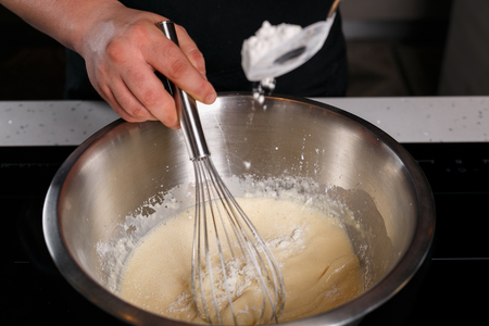 Chef adding flour and stirring at the same timeの写真素材