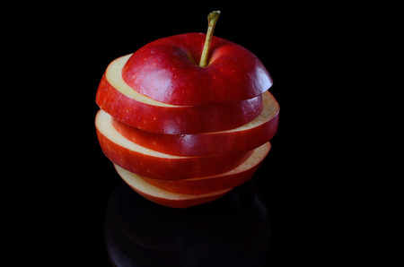Juicy red apple on a black background. Cut apples isolated on black.の写真素材