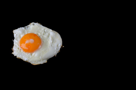 Fried egg on a black background, delicious breakfast. Fried egg isolated on black.の写真素材