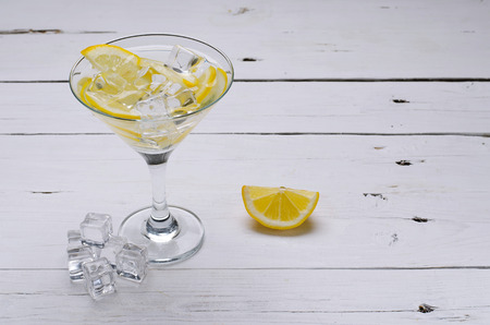 Lemon cocktail on a wooden table. Glass of martini with ice cubes.の写真素材