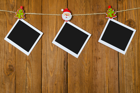 Blank photo frames on a wooden background. Christmas decorations on a rope.の写真素材