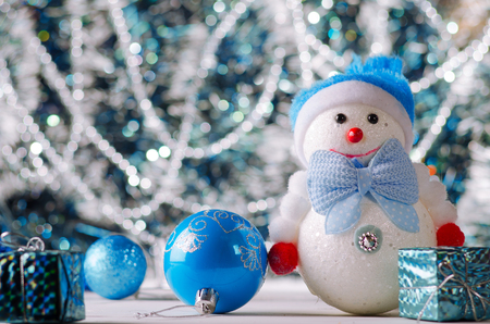 Christmas decorations on the background bokeh closeup. New Year card. Snowman and ball on a background of glitter.の写真素材