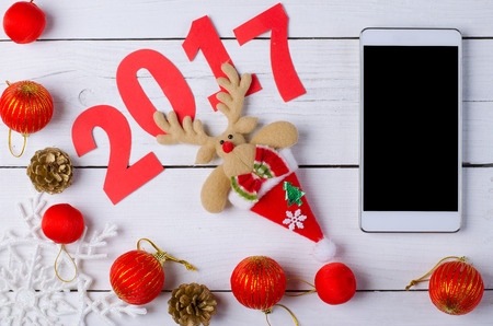 Christmas smartphone on a wooden table, top view. Background for New Year`s greetings, Christmas...