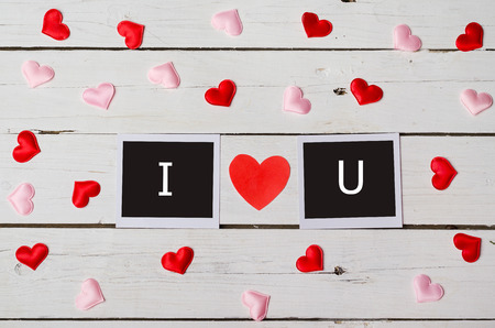 Background Valentine's Day, the inscription I love you. Hearts scattered on a wooden table.の写真素材